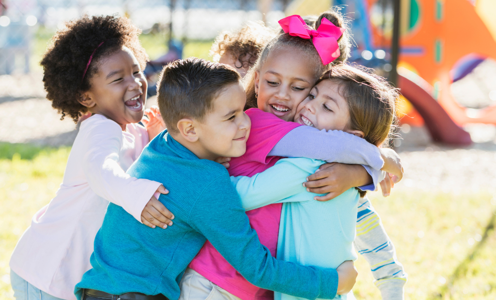 a group of diverse children holding hands and dancing and singing in a circle